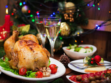 Baked turkey or chicken. The Christmas table is served with a turkey, decorated with bright tinsel and candles. Fried chicken, table. Christmas dinner.